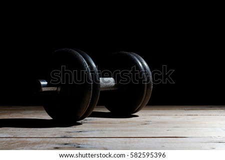 Dumbbells on wood on a black background