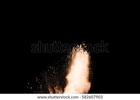 abstract brown dust explosion on  black background.abstract brown powder splatted on black background,Freeze motion of brown powder exploding