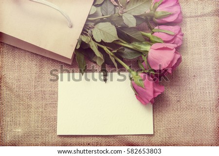 background with roses and greeting card. toned photo