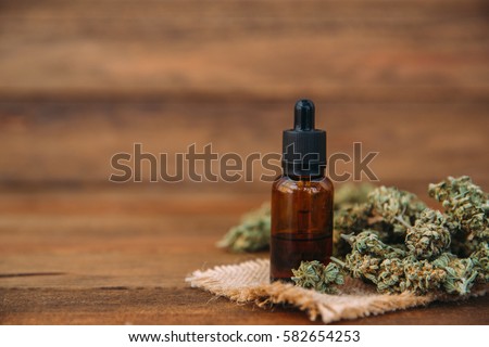 Medicinal cannabis with extract oil in a bottle Royalty-Free Stock Photo #582654253