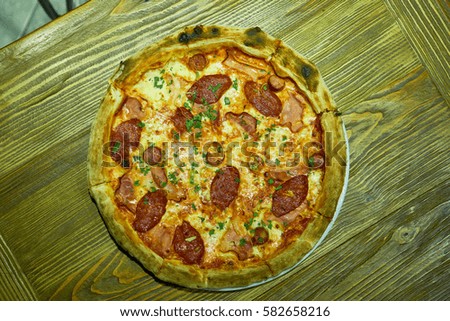 Pizza on a plate on a wooden table.                               