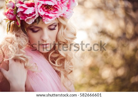 A young girl in floral wreath in nature