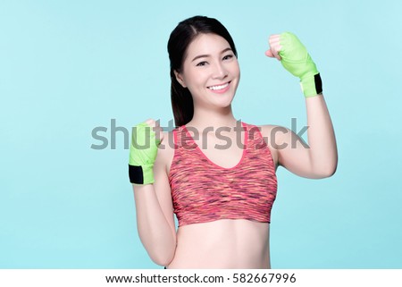 Asian woman boxing exercise with hands wrap. Beauty face and natural makeup sports bra outfit. Isolated over blue background