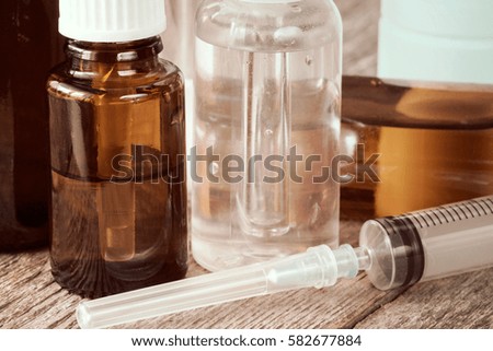Syringe and various medications on the wooden background