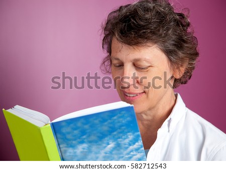 Portrait of smiling senior woman reading book