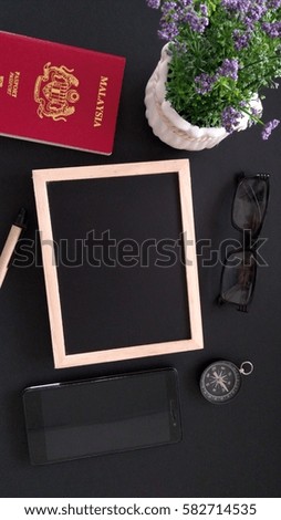  Glass, chalk board, flower, pen, smartphone, classic compass and passport on black background.Copy Space, low light, selective focus, vertical