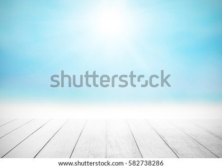 The blur cool sea background with wood floor foreground on horizon tropical sandy beach; relaxing outdoors vacation with heavenly mind view at a resort deck touching sunshine, sky surf summer clouds. Royalty-Free Stock Photo #582738286