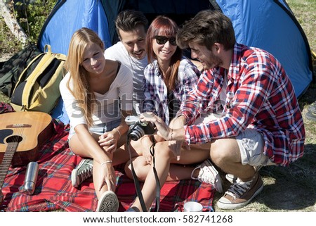group of young adult watching photos on digital camera