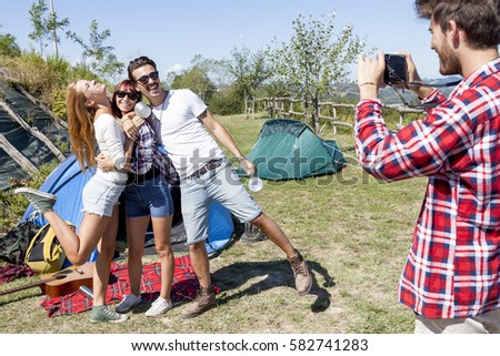 group of friends on vacation takes photos at the campsite