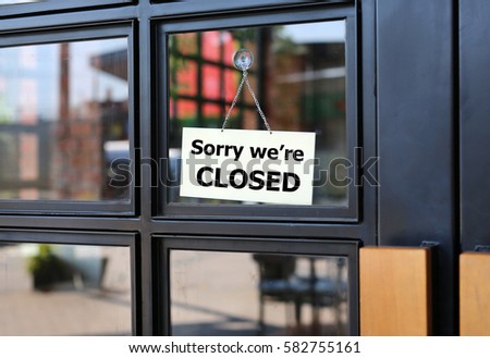 Sorry we're CLOSED sign board hanging on door of cafe. Royalty-Free Stock Photo #582755161