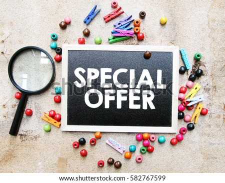 A concept image of a colorful beads and cute clothespin with a magnifying glass over a brown texture background with a chalkboard and a word SPECIAL OFFER