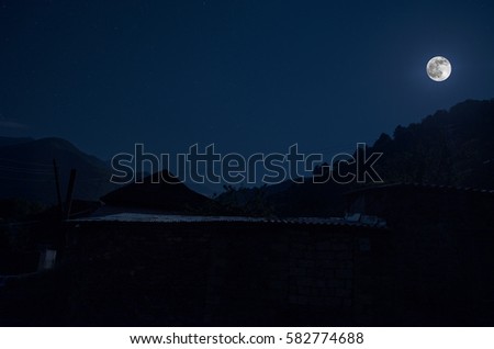 Beautiful landscape of Ilisu mountain village on the hillside. Big Caucasus mountains at night in full moon light. Azerbaijan nature