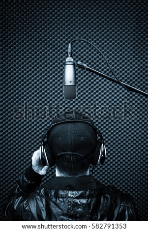 back of male singer singing in recording studio or voice actor for movies post production