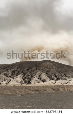 Bromo volcano mountain with explosion smoke on sky background - Indonesia