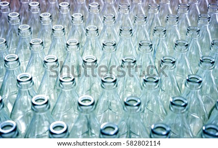 Empty glass bottles in factory to fill with drink Royalty-Free Stock Photo #582802114