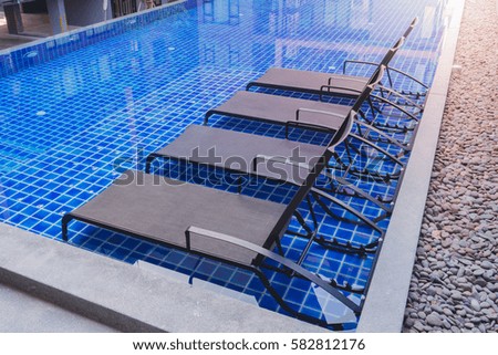 Chaise lounges in swimming pool
