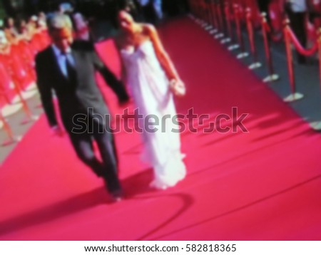 Blurred image. Red carpet entrance with golden stanchions and ropes. Celebrity nominees go to the premiere. Stars on the festive awarding of prizes awards