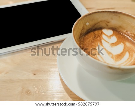 Close up white coffee cup and tablet on wood desk
