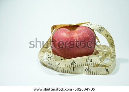A close up of Red Apple and a measure tape isolate on a white background. A Diet and  Healthy concepts.