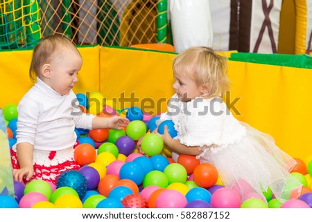 Little cute girl playing in the pool with balls. Birthday with fun games in the entertainment center.