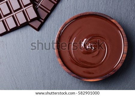 Melted chocolate and bar chocolate. Slate background. Copy space Top view