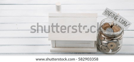 Concept image of housing loan, with japanese coins in mason jar and wooden model house