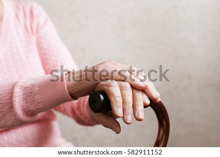 Hands of an old woman with a cane Royalty-Free Stock Photo #582911152