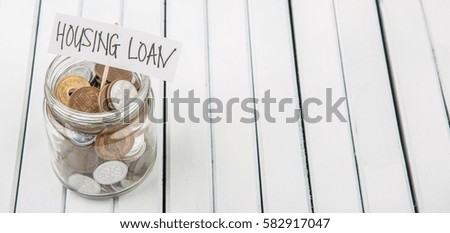 Conceptual image of housing loan with Japanese coins in mason jar over wooden background