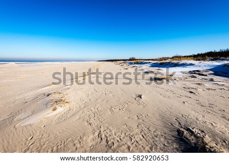 frozen beach in cold winters day with colorful sky and ice