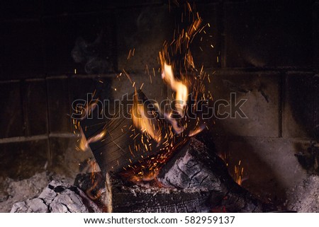fireplace burning, the flames in the fireplace and sparks, prepare to fire on a background of a brick wall, wood and ash, fire closeup.