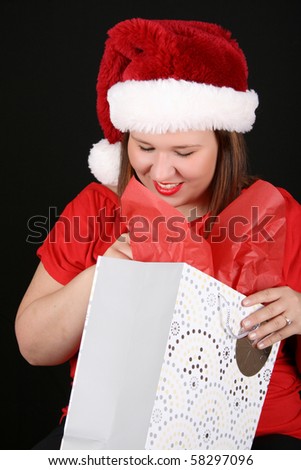 Beautiful caucasian brunette looking inside her christmas gift bag
