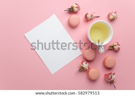 Green tea and pastel french macarons cakes on pink background. Dessert in a garden. Flat lay. Free text space.