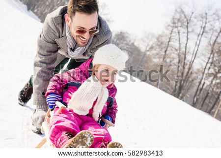 Young Father Sledding With Kid And Enjoying On Sunny Winter Day