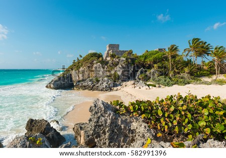 The Caribbean Sea with turquoise waters and white sand beach as a backdrop for the Tulum Maya ruins, Mexico. Royalty-Free Stock Photo #582991396
