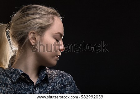 sad woman profile on black background