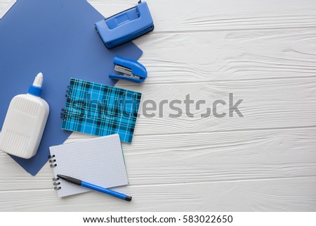 blue stationery. notebooks, pens,glue on white wooden background Royalty-Free Stock Photo #583022650