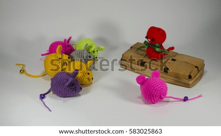 Knitted small red cat on a wicker basket and colorful mouse. Handmade. Toy