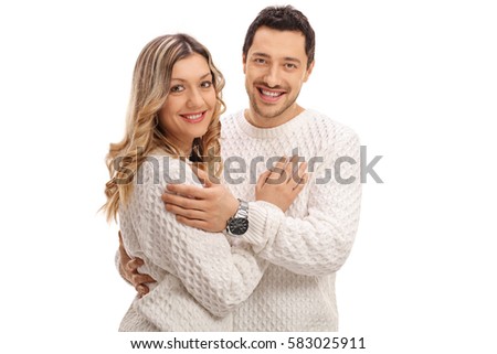 Happy young couple in an embrace smiling and looking at the camera isolated on white background
