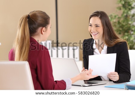 Boss attending to an employee during a job interview in a desktop at office Royalty-Free Stock Photo #583026820