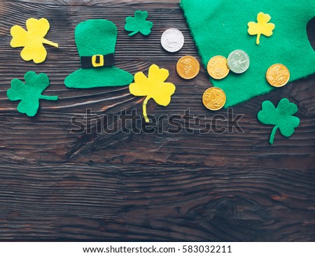 Traditional Irish St. Patrick's Day symbols hat, clover leafs and coins on wooden background .Space for your text Royalty-Free Stock Photo #583032211