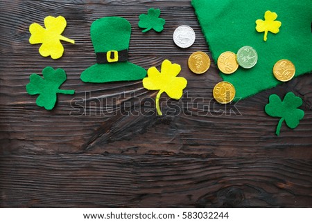 Traditional Irish St. Patrick's Day symbols hat, clover leafs and coins on wooden background .Space for your text