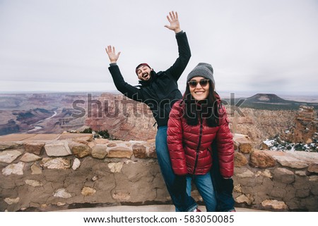 Happy couple having fun and taking funny picture for social media at Grand Canyon viewpoint, Arizona, USA.