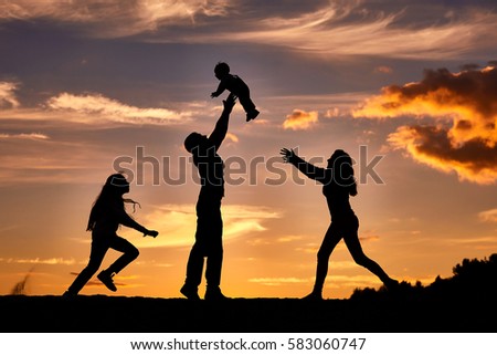 happy family playing on the sunset background. 