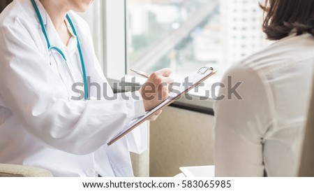 Doctor (gynecologist or psychiatrist) consulting and diagnostic examining woman patient's health in medical clinic or hospital healthcare service center Royalty-Free Stock Photo #583065985