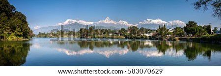 View at Annapurna mountain range and its reflection in Phewa lake in Pokhara, Nepal Royalty-Free Stock Photo #583070629