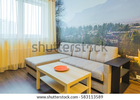 The interior of the living room in orange tones with a coffee table and sofa