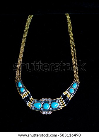 plastic blue gold necklace on a black background
