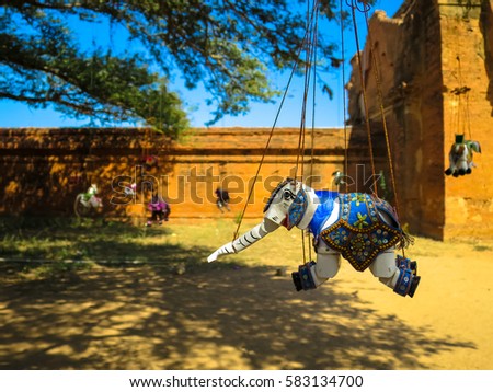 Ornamented elephant marionette puppet souvenir hanging under the big tree