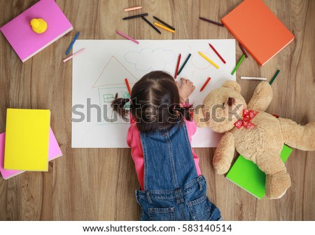 Little Asian girl drawing with color pen in paper on floor of school, Education and preschool concept