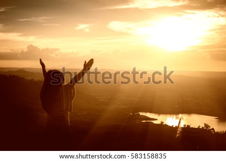 Girl arms raised to the sky, thank God. Royalty-Free Stock Photo #583158835